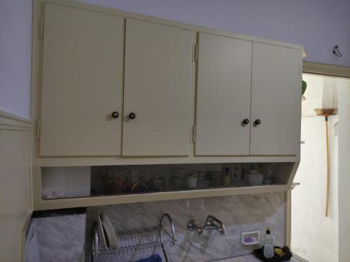 a kitchen with white cabinets and a sink at Lemon Apartment near to Pireaus Port in Piraeus