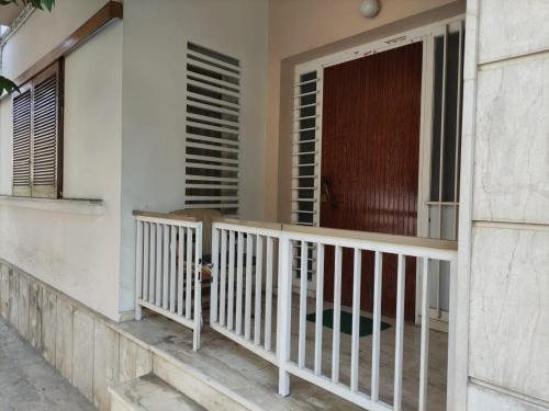 a balcony of a house with a wooden door at Lemon Apartment near to Pireaus Port in Piraeus
