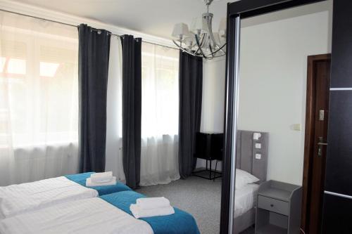 Habitación de hotel con 2 camas y espejo en Villa Victoria, en Varsovia