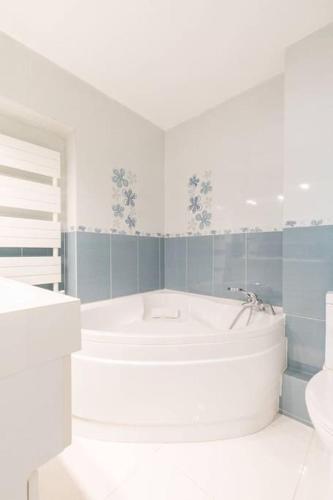 une salle de bain blanche avec une baignoire et un lavabo dans l'établissement Les Bambous, à Dijon