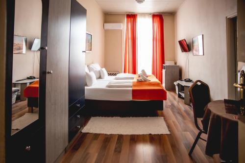 a hotel room with a bed and a window at Hotel Kapos in Kaposvár