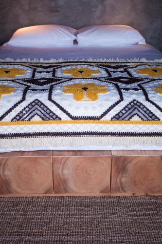 a bed with a blanket on top of it at Lava Homes in Santo Amaro