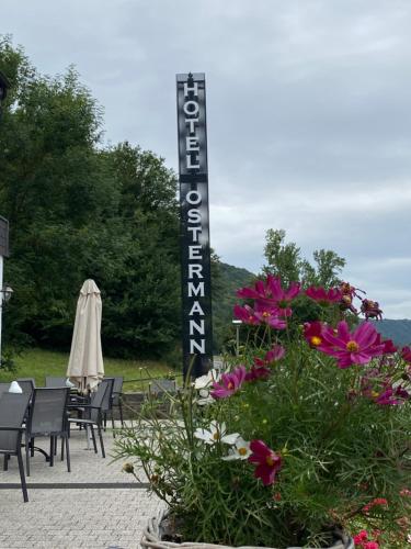 una señal para la entrada a un restaurante con flores en Hotel Ostermann en Treis-Karden