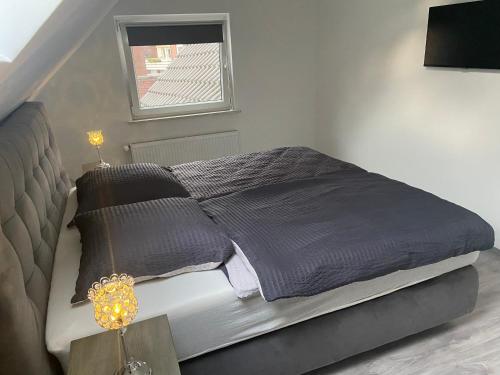 a bed with gray blankets and pillows in a bedroom at Gemütliche Ferienwohnung in Stadtnähe in Oldenburg