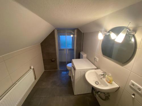 a bathroom with a sink and a toilet and a mirror at Gemütliche Ferienwohnung in Stadtnähe in Oldenburg