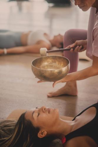 a woman laying on the floor with a bowl above her head at 7Pines Resort Ibiza, part of Destination by Hyatt in San Jose