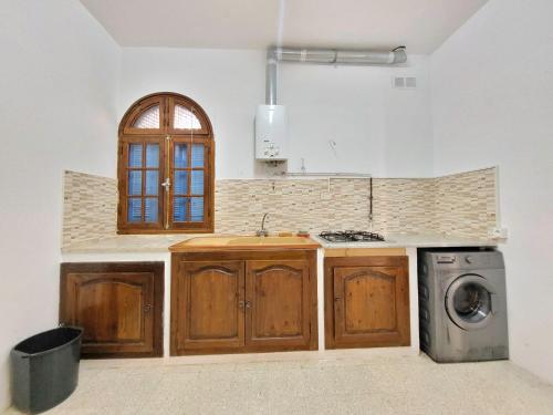 uma cozinha com um lavatório e uma máquina de lavar roupa em Maison Karima em Djerba