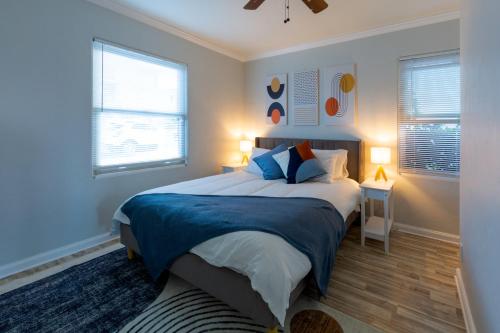 a bedroom with a large bed and two windows at Ocean Beach Luxury + a Private Fireworks Show! in San Diego