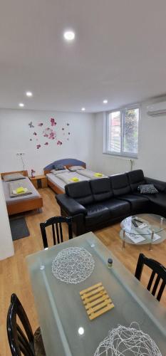 ein Wohnzimmer mit einem Sofa und einem Tisch in der Unterkunft Apartman MURKO P-2 