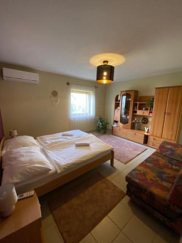 a bedroom with a large bed and a kitchen at Varga Apartman in Balatonberény