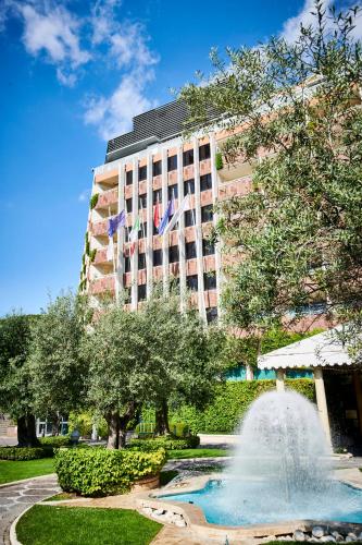 a fountain in front of a hotel with a building at Rome Cavalieri, A Waldorf Astoria Hotel in Rome