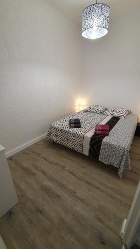 um quarto com uma cama e piso em madeira em Appartement centre-historique 70 m2 em Fréjus