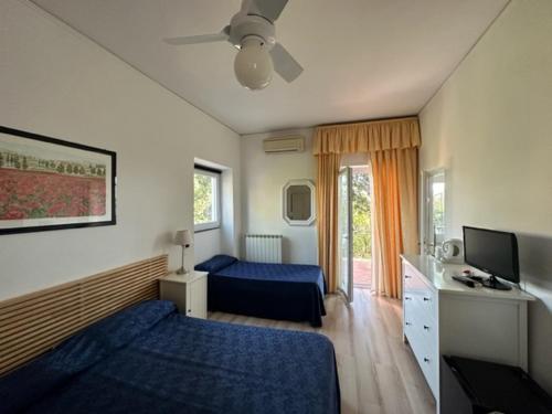 una camera d'albergo con due letti e una televisione di Hotel L'Isola a Santa Marinella