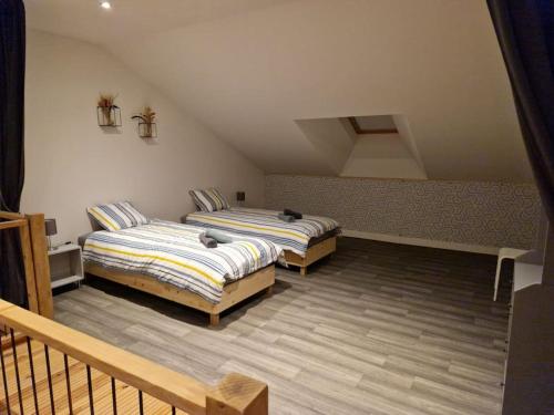 a bedroom with two beds in a attic at Gîte de l'étoile, 6 pers. spacieux avec extérieur in Villers-devant-Dun