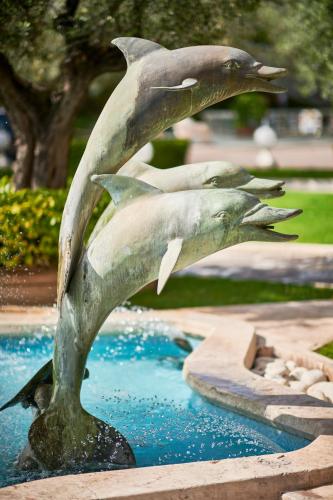 a statue of dolphins jumping out of a fountain at Rome Cavalieri, A Waldorf Astoria Hotel in Rome