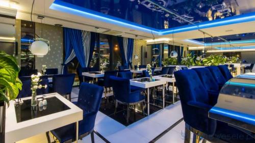 ein Restaurant mit blauen Stühlen und Tischen in der Unterkunft Luxury Apartments Seveeu in Warschau