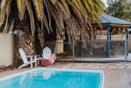a swimming pool with two chairs and a gazebo at Yarranvale on Gladstone - A Gorgeous Country Abode in Mudgee