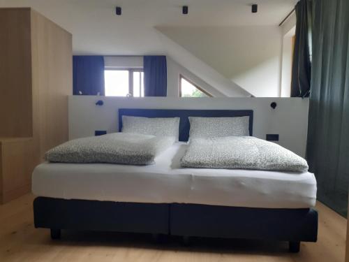 a bedroom with a blue and white bed with two pillows at san Antonia B&B Neu Eröffnung Sommer 2024 in Caldaro