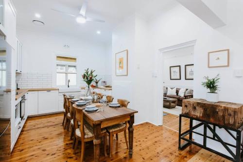a kitchen and living room with a wooden table and chairs at Yarranvale on Gladstone - A Gorgeous Country Abode in Mudgee