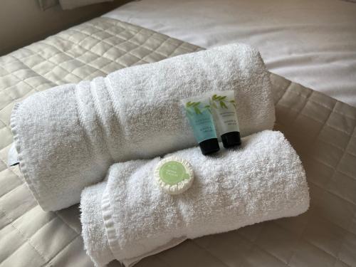 un par de toallas y una botella de jabón en una cama en One Queens Gardens, Sea View Apartment, Eastbourne., en Eastbourne