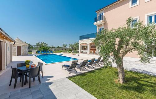 a patio with a table and chairs next to a swimming pool at Stone Luxury Villa in Gajana