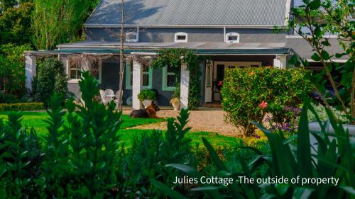 una casa con un caballo sentado en el patio delantero en Julie's Cottage, en Riebeek-Kasteel