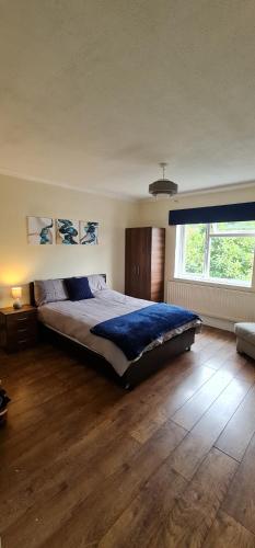 a bedroom with a large bed and a large window at 5 Bedroom Spacious villa in Byfleet