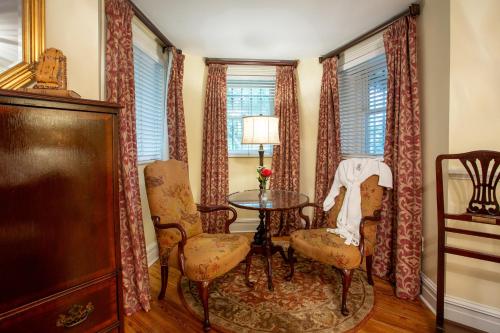a dining room with a table and chairs and windows at Kehoe House, Historic Inns of Savannah Collection in Savannah