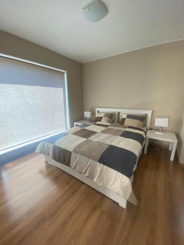 a bedroom with a large bed and a large window at Holiday HOUSE Vecāķi in Rīga
