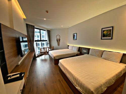 um quarto de hotel com duas camas e uma televisão de ecrã plano em Apec Mandala Mui Ne R2223 em Ấp Thiẹn Ái