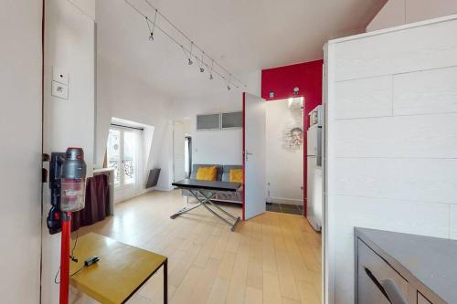 een woonkamer met een koelkast en een tafel. bij 2 pièces Lumineux & Calme (28m²) in Parijs