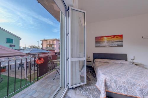 una camera da letto con balcone, letto e finestra di Affittacamere SS. Smile a Loreto