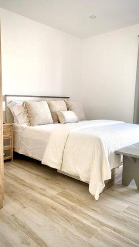 1 dormitorio con 1 cama con sábanas blancas y mesa en Sea & See - Deluxe Apartment, en Lagos
