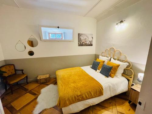 - une chambre avec un lit doté d'une couverture jaune et d'une fenêtre dans l'établissement Maison Gabriel - Logement charmant au cœur de la Cité Médiévale - T3 75m2, à Albertville