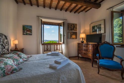 een slaapkamer met een bed, een stoel en een raam bij Luxury Villa Spoleto in Spoleto