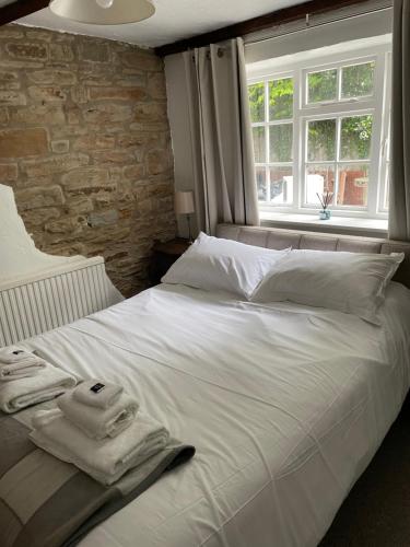 a bedroom with a white bed with a window at Barlow Country Club - Mill Farm Cottages in Dronfield