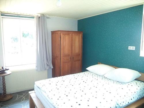 a bedroom with a bed and a blue wall at Espace Famille Montmillon in Chamblay