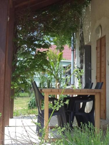 a wooden table and chairs on a patio at Espace Famille Montmillon in Chamblay