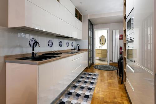 a kitchen with white cabinets and a sink at Audrey by Unique Rooms in Burgos