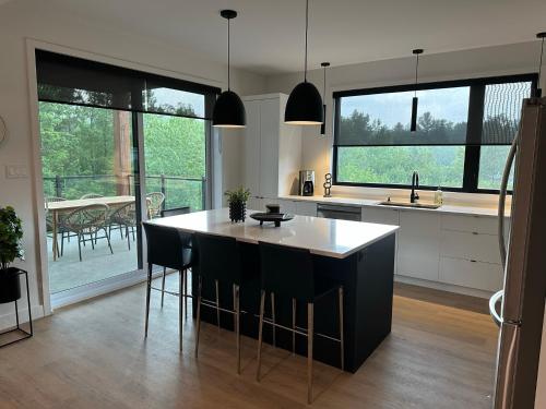 uma cozinha com uma ilha com bancadas a preto e branco em Le Joford em Orford