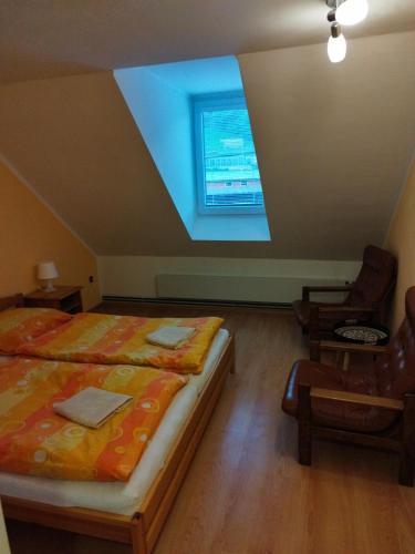 Un dormitorio con una cama grande y una ventana en U Cvečků 