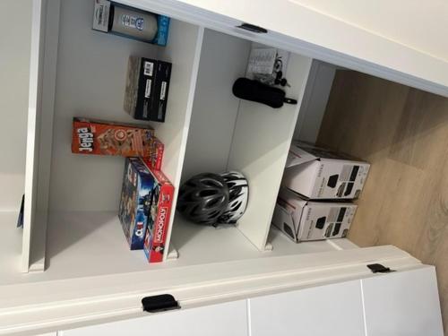 a shelf in a kitchen with games and other items at Le Joford in Orford