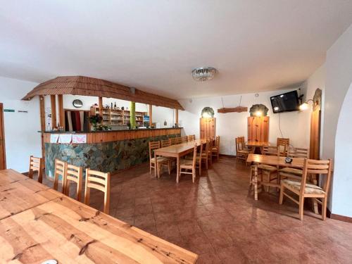 un restaurante con mesas y sillas de madera y un bar en U Cvečků, 