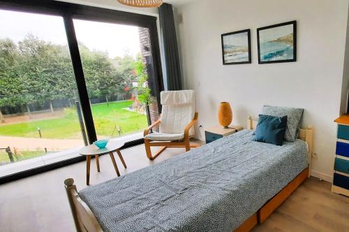 a bedroom with a bed and a large window at BnB Waterzicht in Wijnegem