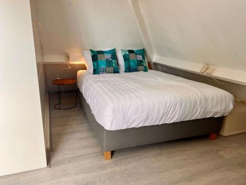 a bed with blue pillows in a small room at Church Square Studio in Zandvoort