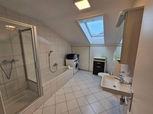a bathroom with a shower and a sink and a bath tub at Ach18, Bregenz, Vorarlberg Apartments in Bregenz