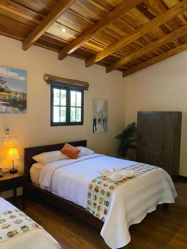 a bedroom with two beds and a window at Millenium Manuel Antonio Park and beach in Manuel Antonio