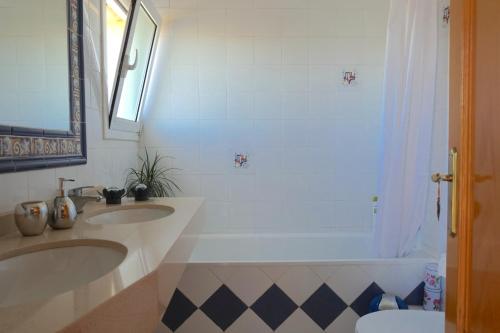 a bathroom with two sinks and a tub at Habitación Atalaya in Olivella