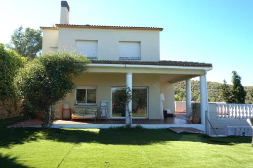 ein weißes Haus mit Rasen davor in der Unterkunft Habitación Atalaya in Olivella