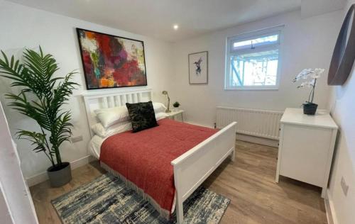 een slaapkamer met een bed met een rode sprei bij Shotley Bridge Blackhill - Stylish and Spacious 4 Bedroom 3 Bathroom Townhouse in Consett